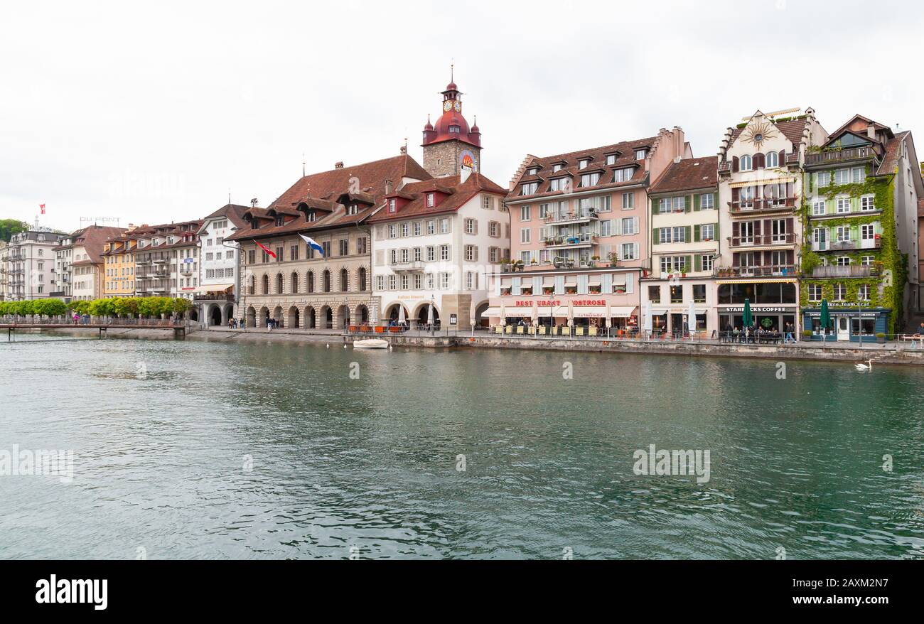 Lucerna, Svizzera - 7 maggio 2017: Paesaggio urbano con torre dell'orologio del vecchio municipio sullo sfondo. La gente comune cammina per la strada Foto Stock