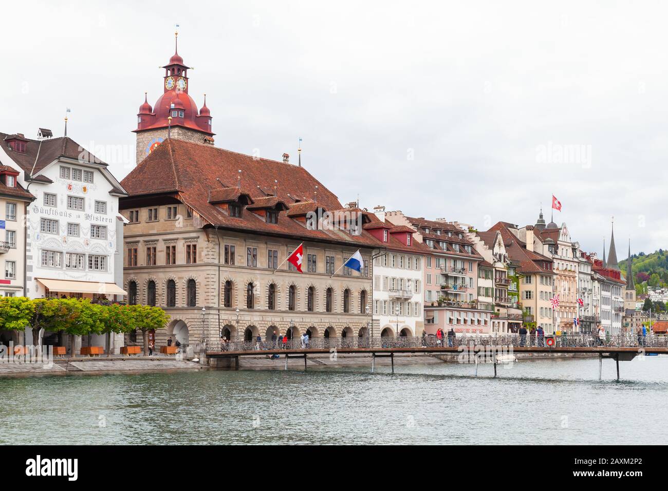 Lucerna, Svizzera - 7 maggio 2017: Paesaggio costiero con torre dell'orologio del vecchio municipio sullo sfondo. La gente comune cammina per la strada Foto Stock