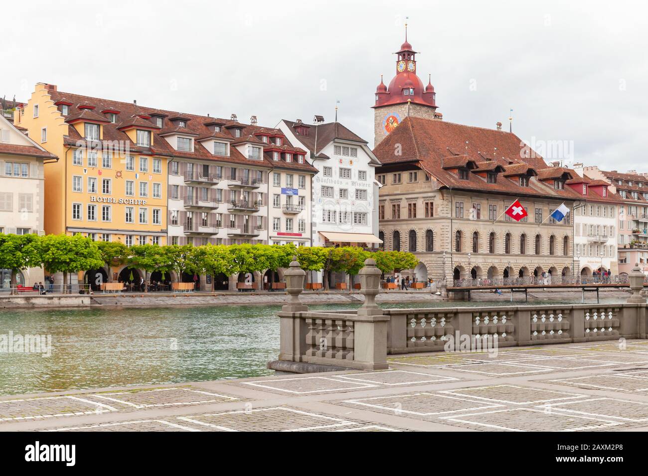 Lucerna, Svizzera - 7 maggio 2017: Paesaggio urbano costiero con torre dell'orologio del vecchio municipio sullo sfondo. La gente comune cammina per la strada Foto Stock