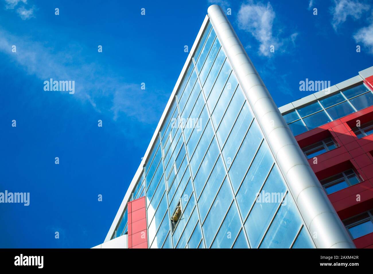 Grattacielo con finestre a specchio e cielo blu chiaro, vista dal basso Foto Stock