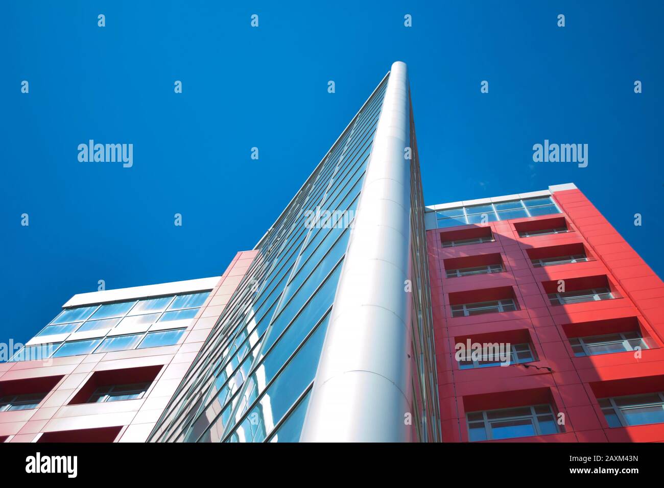 Grattacielo con finestre a specchio e cielo blu chiaro, vista dal basso Foto Stock