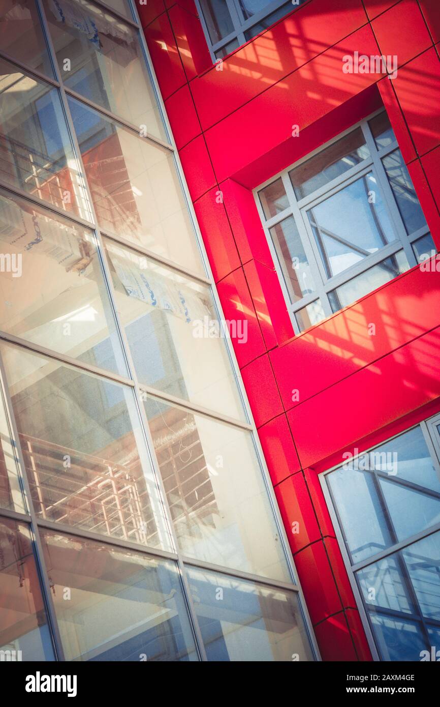 Facciata di un nuovo edificio moderno con una parte trasparente e un filtro a parete rossa Foto Stock