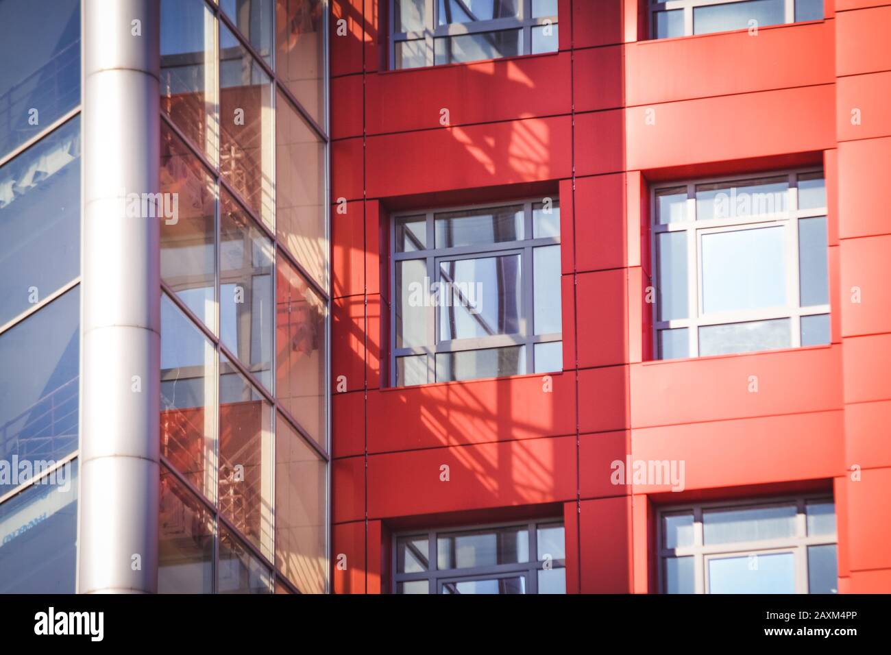 facciata, di fronte alla casa rossa in stile high-tech con finestre quadrate e un muro trasparente in una giornata di sole. Astratto sfondo architettonico Foto Stock