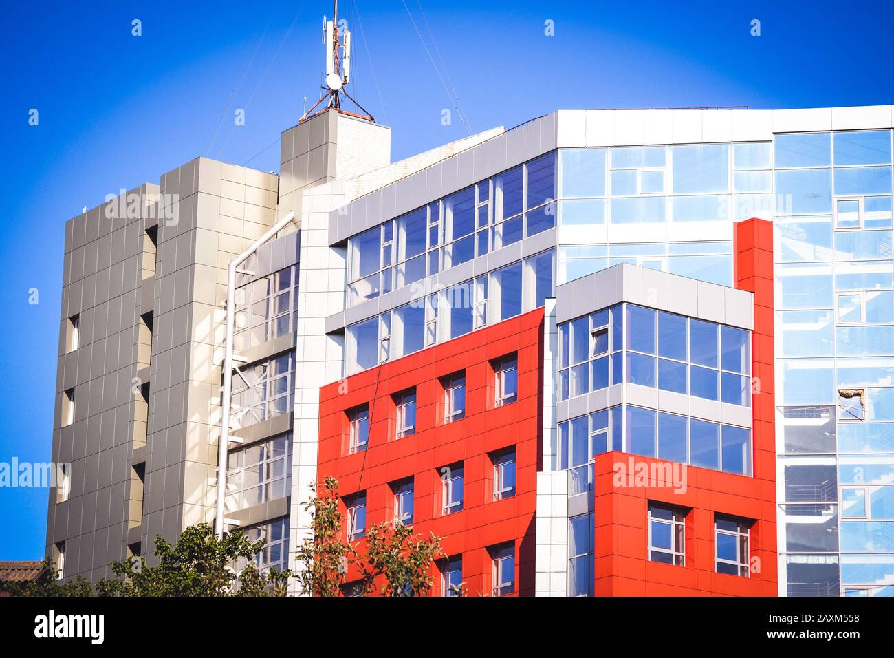 facciata, di fronte alla grande casa rossa e grigia in stile high-tech su una luminosa giornata di sole su sfondo blu cielo Foto Stock
