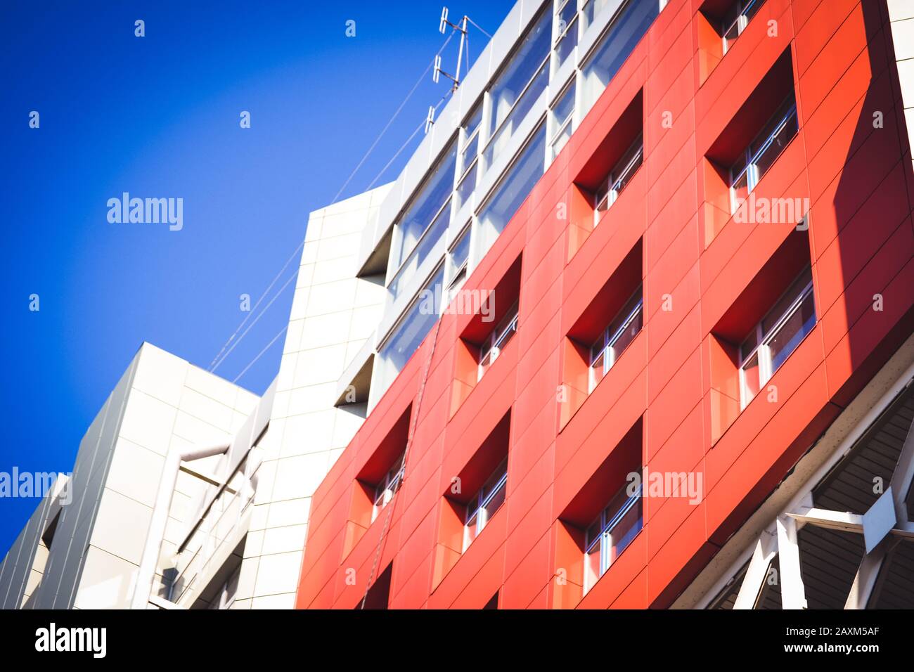 facciata, di fronte alla grande casa rossa e grigia in stile high-tech su una luminosa giornata di sole su sfondo blu cielo Foto Stock