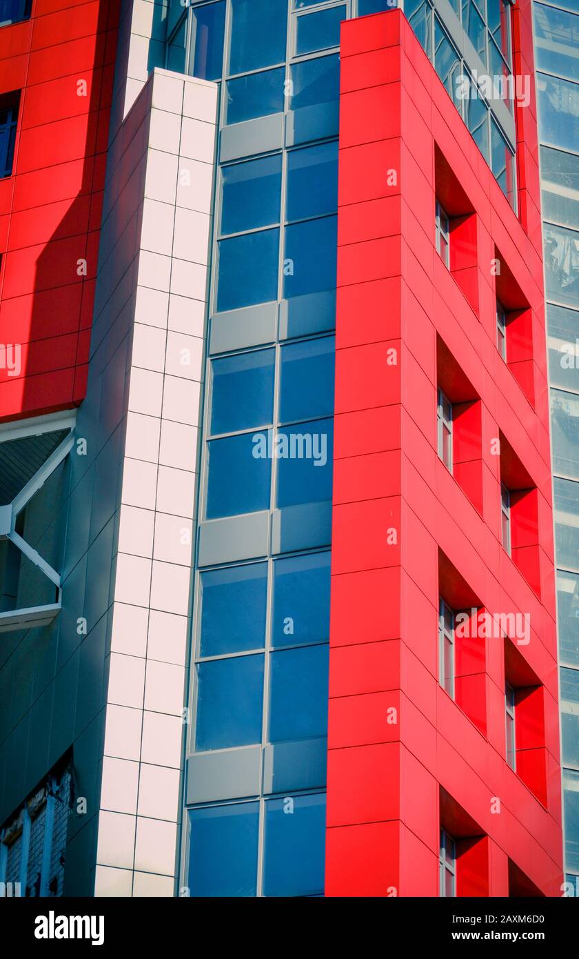 Pareti di colore rosso e blu di un edificio moderno. Parte della facciata dell'edificio nello stile dell'angolo hi-tech Foto Stock