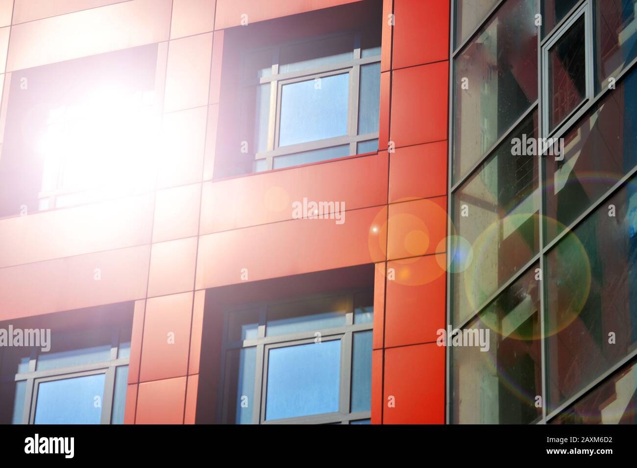 Pareti di colore rosso e blu di un edificio moderno. Parte della facciata dell'edificio nello stile dell'angolo hi-tech. Luce solare Foto Stock