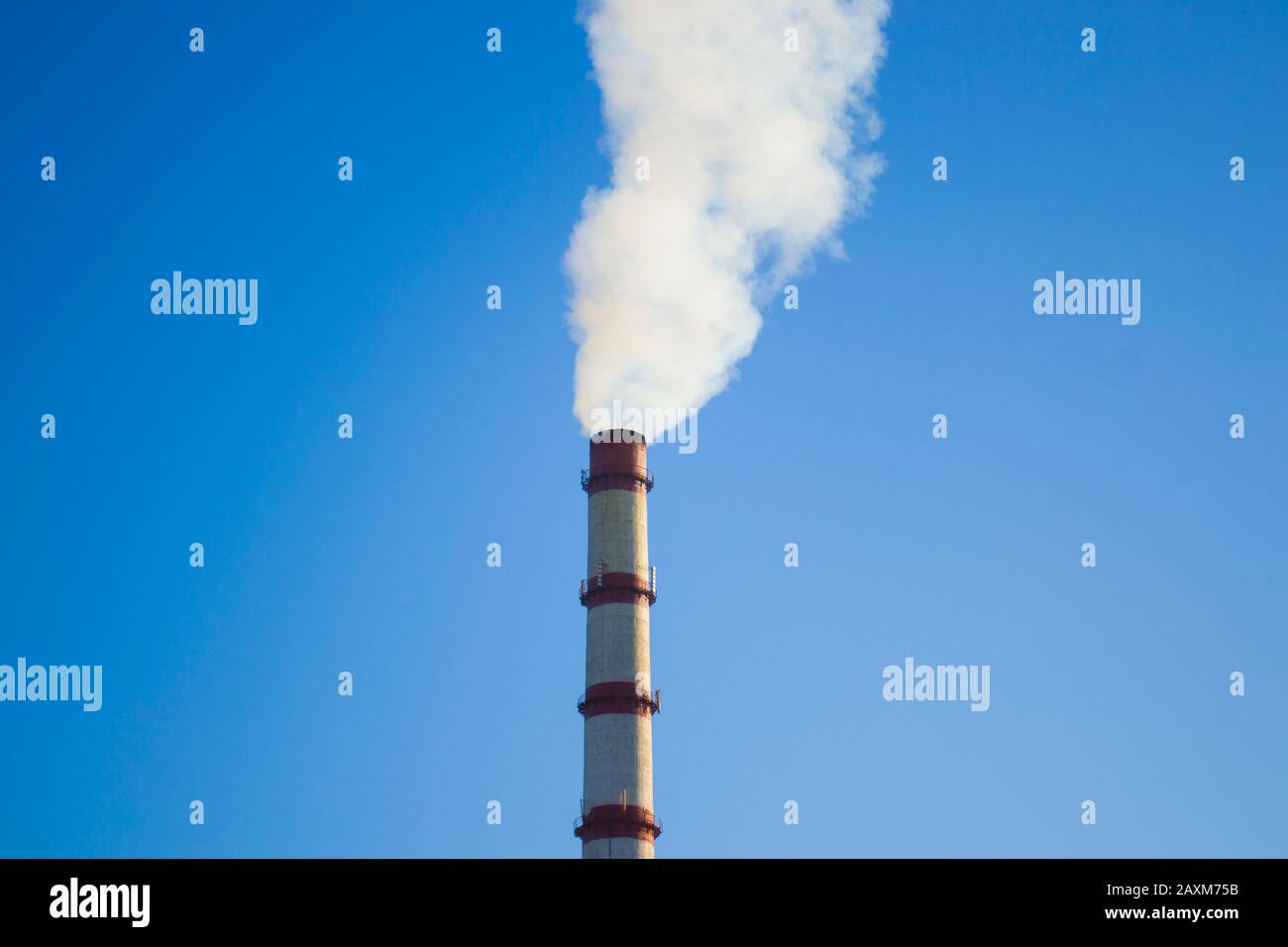 Parte superiore del tubo con il fumo bianco su un puro cielo blu vicino Foto Stock