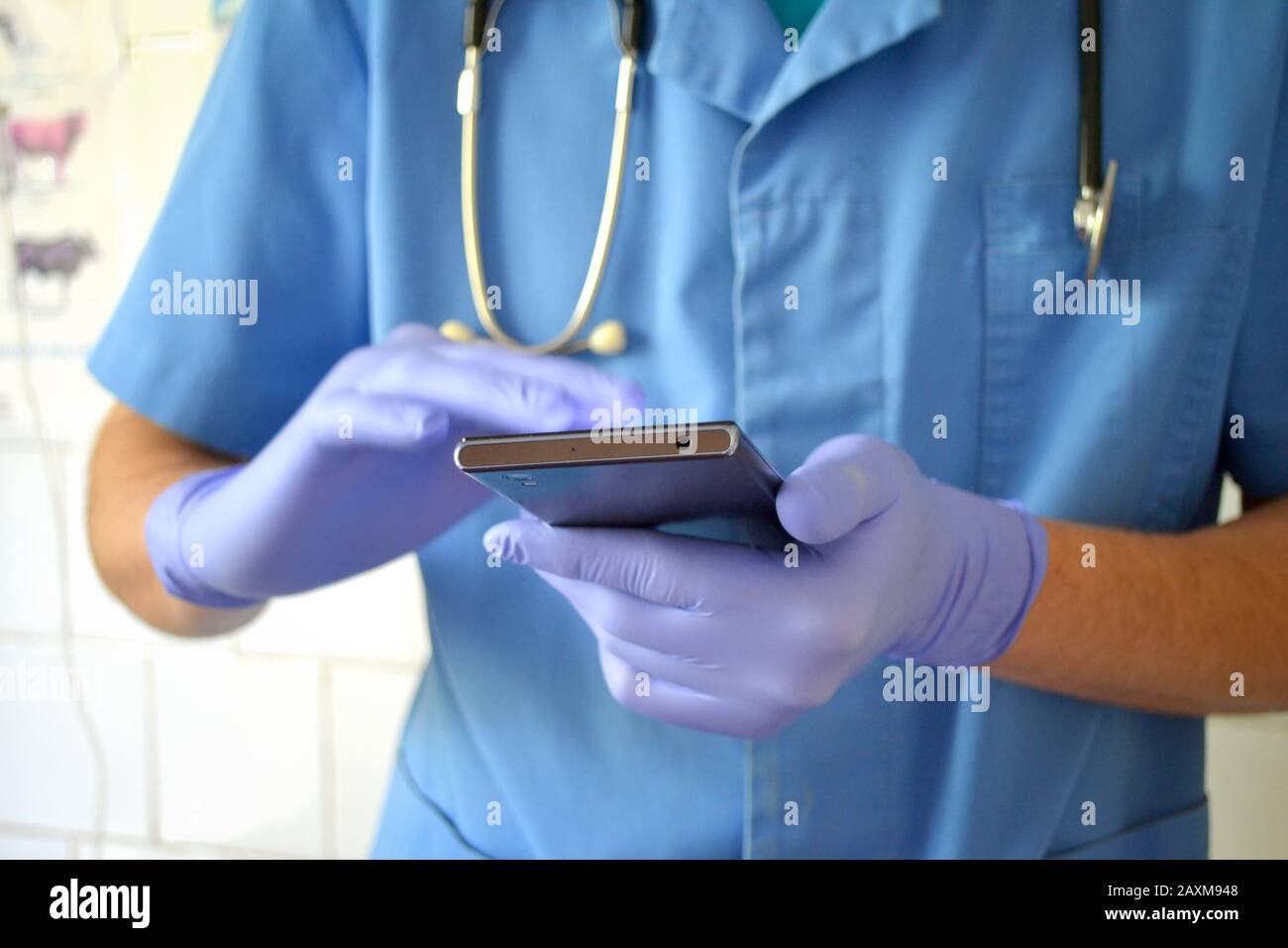 medico in guanti blu e blu funziona su un telefono cellulare primo piano Foto Stock