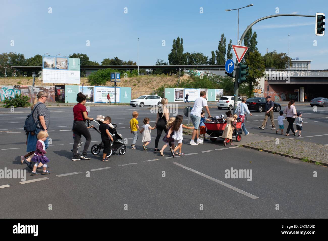 Gruppo di bambini con adulti, estate, Berlino, Germania. Un groupe d'enfants avec des adultes traversent une rue à Berlin, Allemagne. Foto Stock