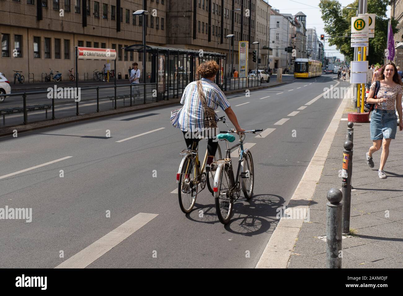 Ein Mann mit zwei Fahrrädern, Berlin, Deutschland. // un uomo che guida due biciclette, Berlino, Germania. Foto Stock