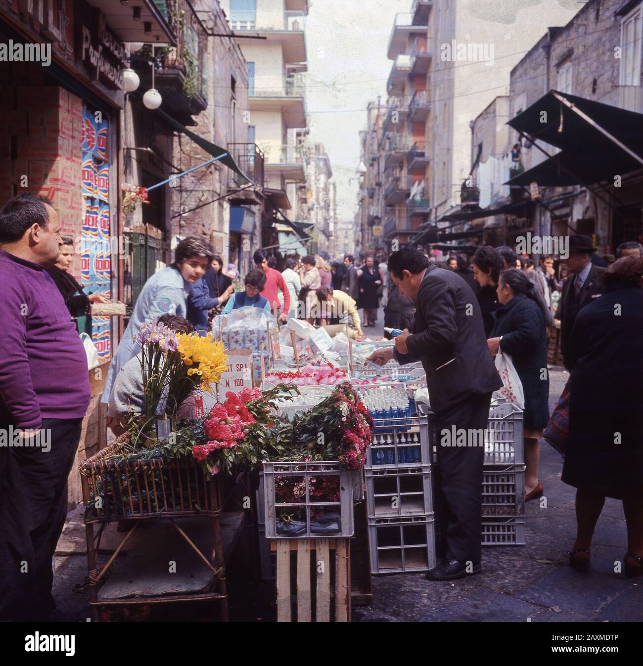 Anni '1960, storica, Roma, Italia, gente del posto che guarda le bancarelle del mercato all'aperto in una delle strade secondarie della città. Foto Stock