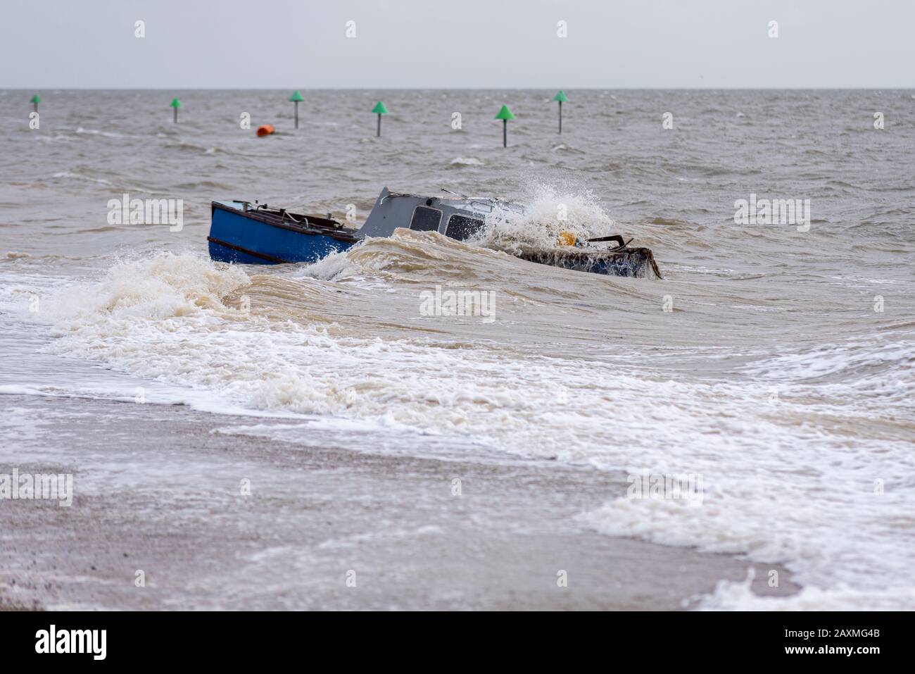 La barca affondamento si è lavata sulla spiaggia durante l'alta marea tempesta dopo Storm Ciara a Southend on Sea, Essex, UK. Onda di crash. Sommerso Foto Stock
