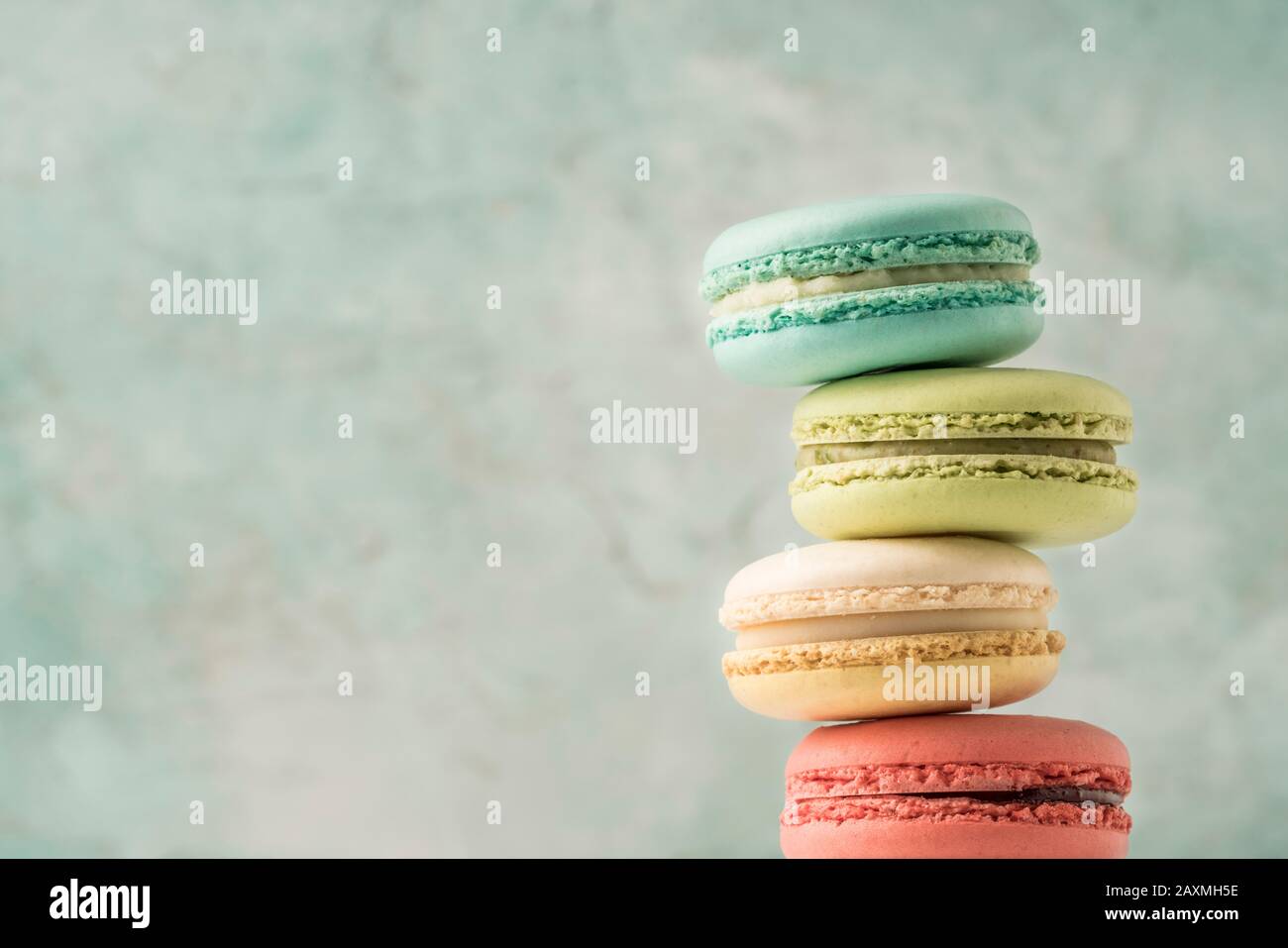 mucchio di macaroni francesi colorati su verde con spazio copia Foto Stock