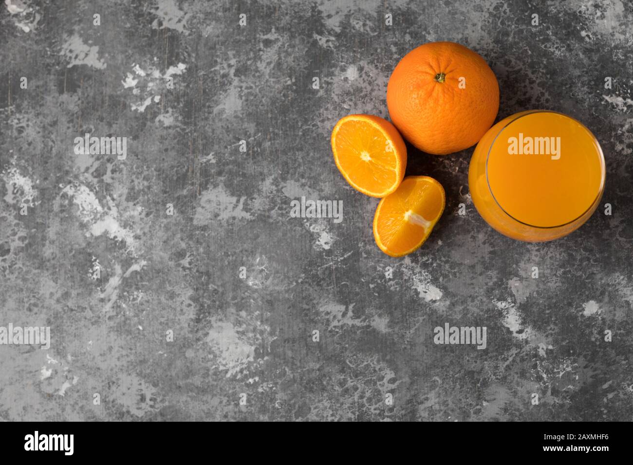 Una mandarino appena spremuta e succo d'arancia in un bicchiere trasparente Foto Stock