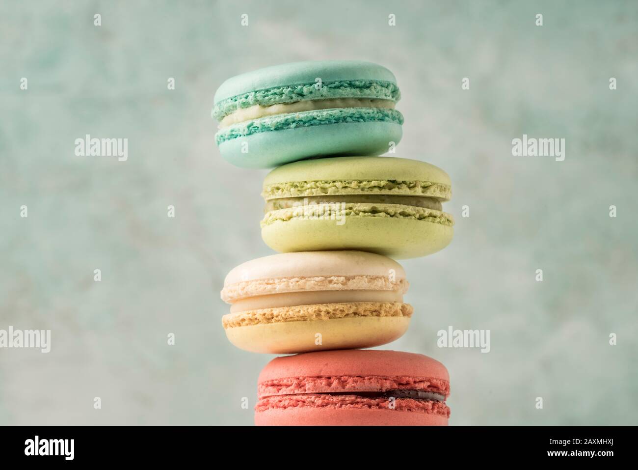 mucchio di macaroni francesi colorati su verde con spazio copia Foto Stock