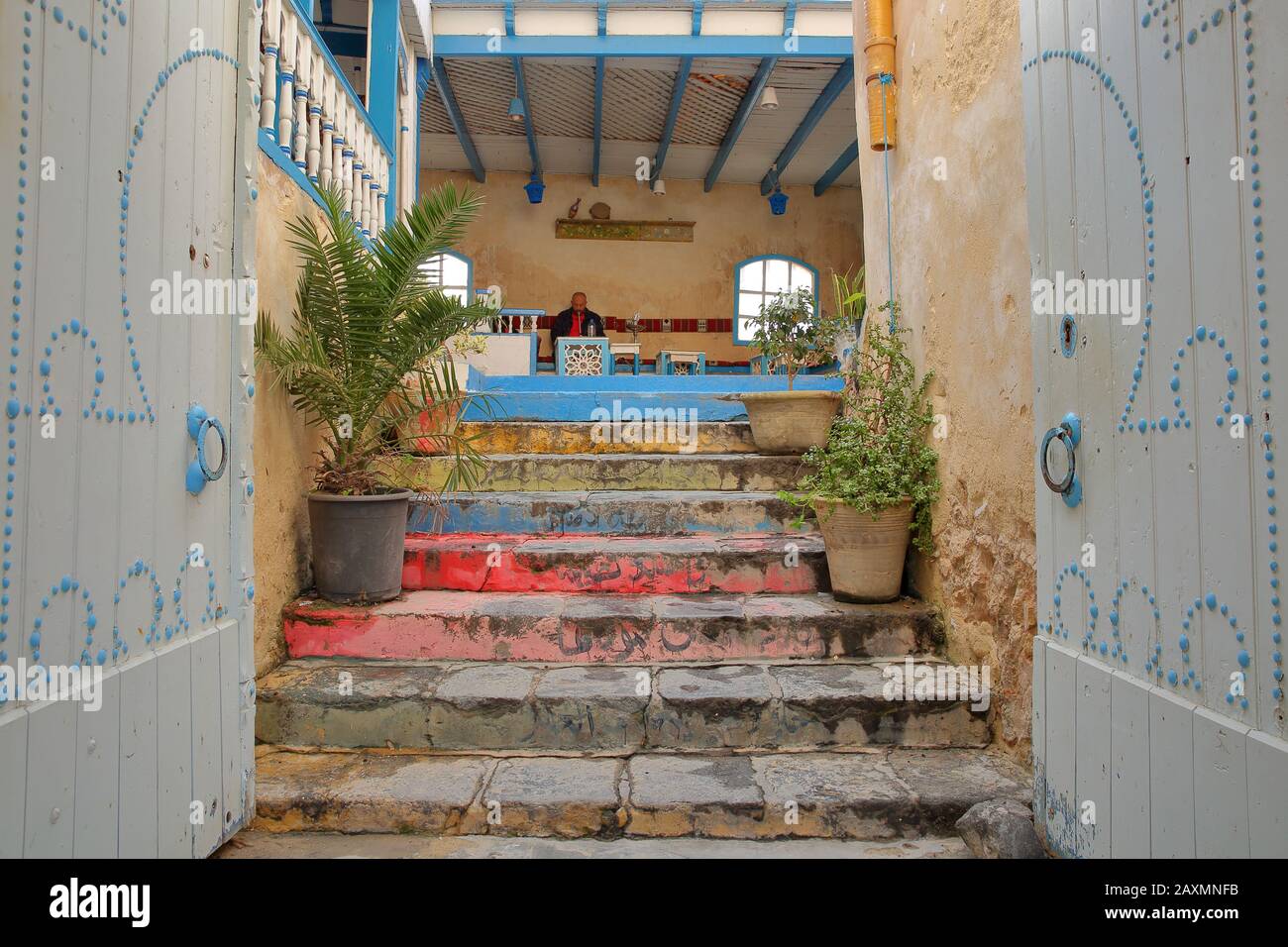 Sfax, TUNISIA - 23 DICEMBRE 2019: L'ingresso colorato al Diwan Cafe, un caffè locale situato all'interno della medina di Sfax, con un chicha uomo fumatori Foto Stock