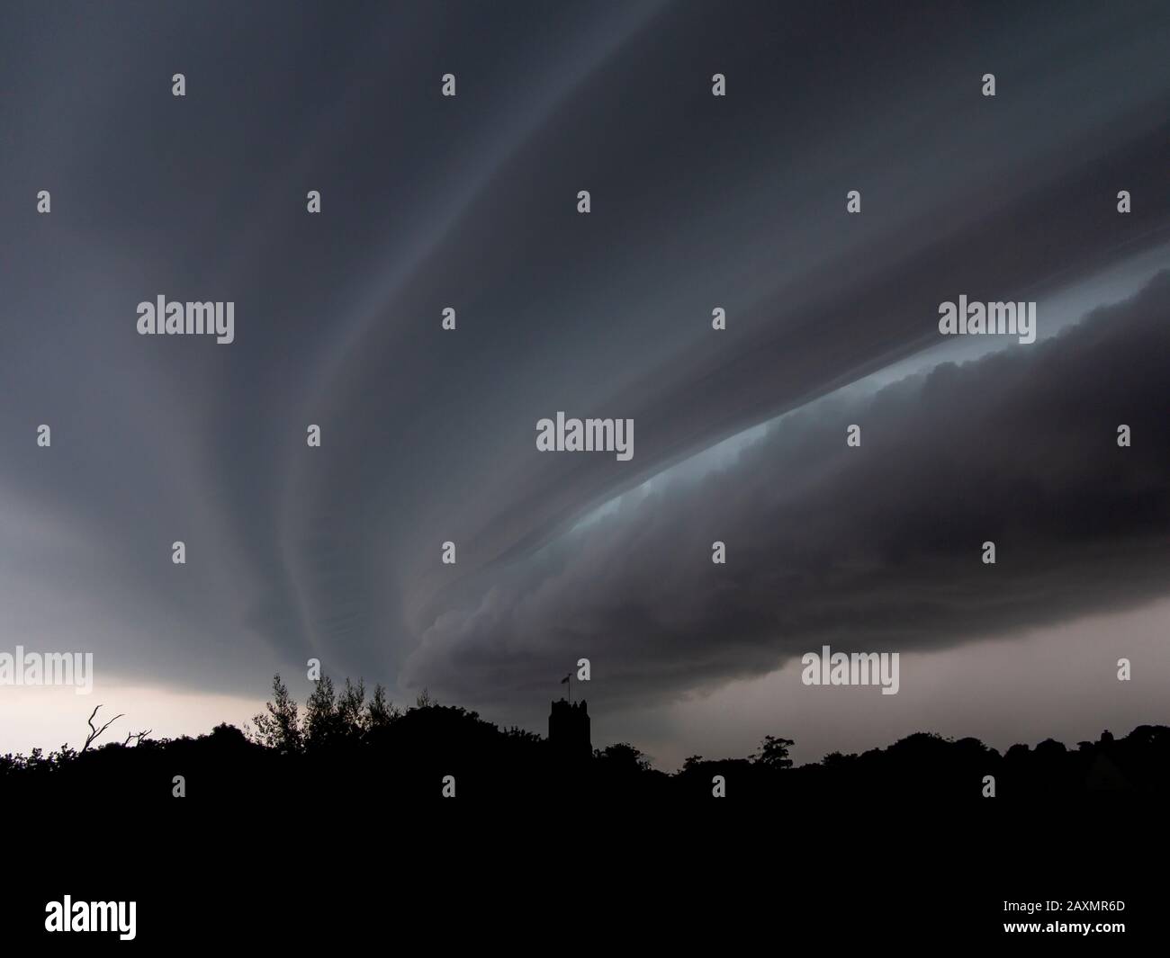 Nubi tempesta che si formano su Aldeburgh, Suffolk, Inghilterra con la Chiesa di San Pietro all'orizzonte Foto Stock
