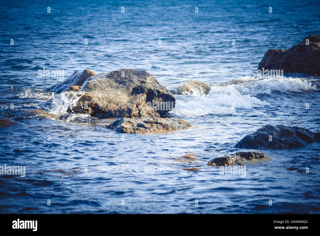 sfondo enormi rocce in mare vicino alla riva, filtro Foto Stock