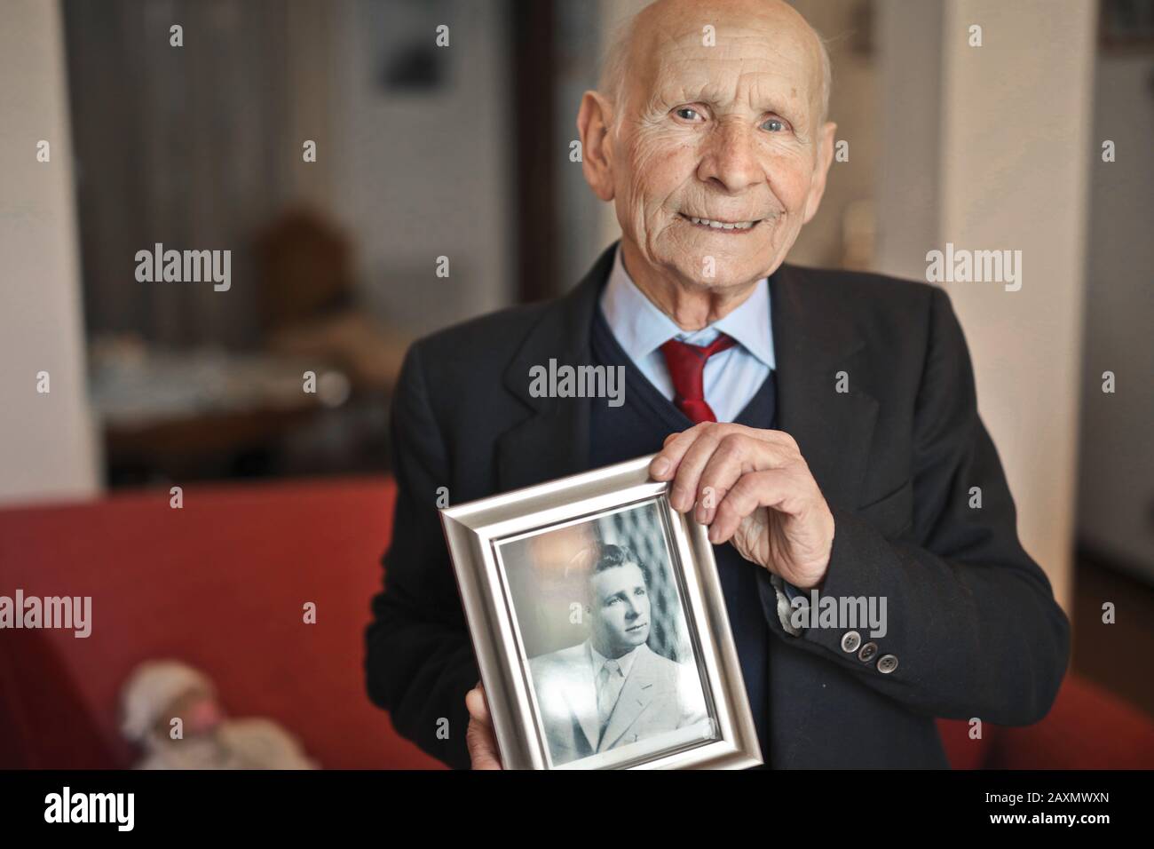 ritratto di un anziano con foto ricordo come giovane Foto Stock