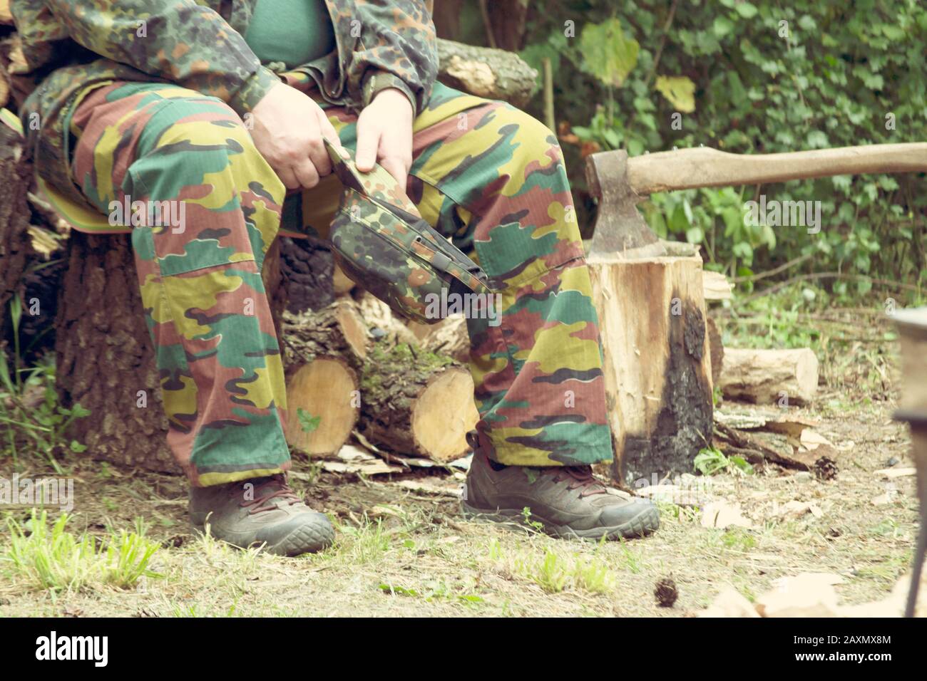 uomo in camouflage seduto nella foresta, filtro, Foto Stock