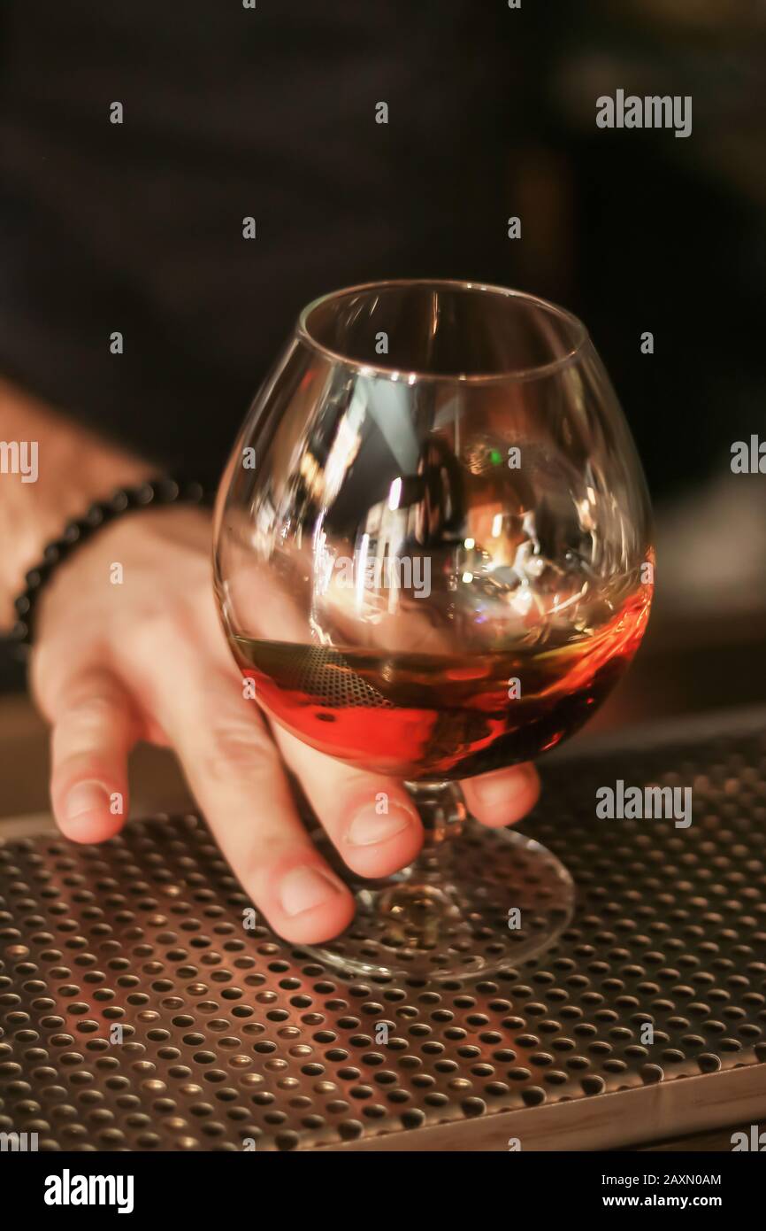 tenere a mano un bicchiere di whisky, bevanda alcolica Foto Stock