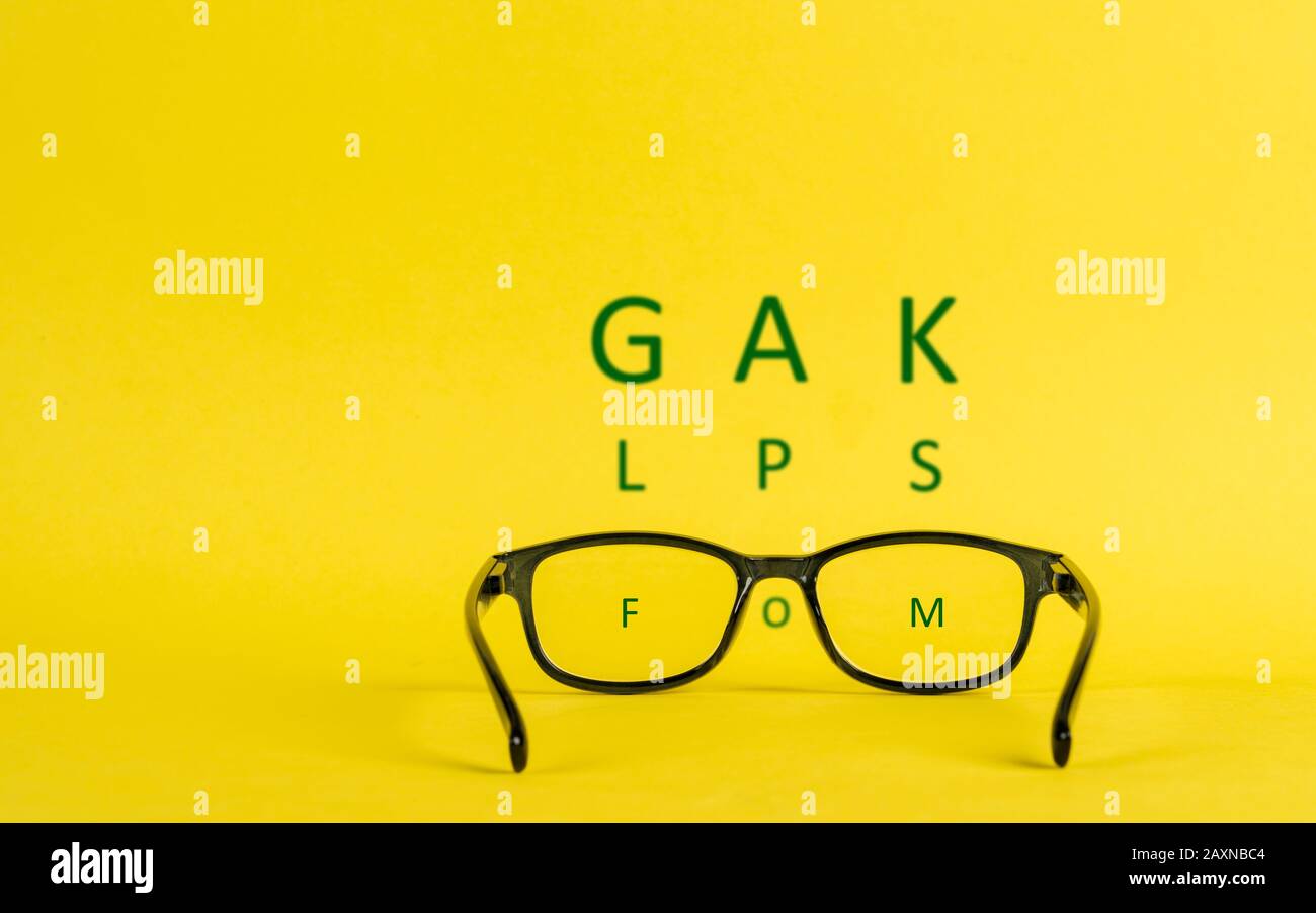 Concetto di miopia raffigurato con occhiali e lettere sfocate Foto Stock