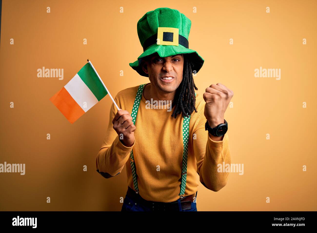 L'uomo americano africano che indossa cappello verde che tiene bandiera  irlandese irlanda celebrare san patricks giorno infastidito e frustrato  gridando con rabbia, pazzo e Foto stock - Alamy