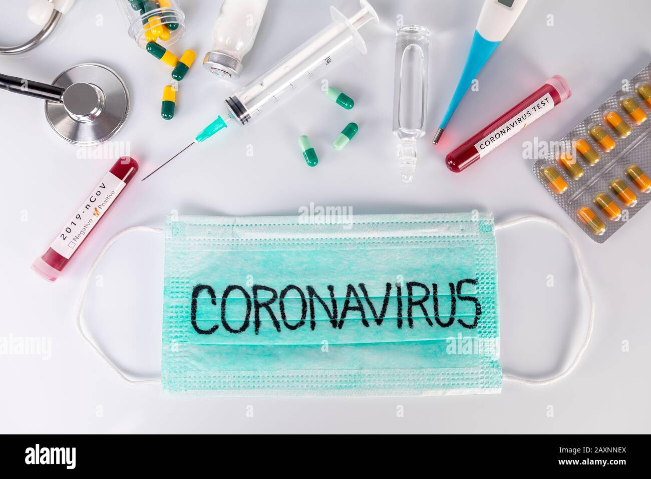 Maschera medica protettiva con testo Coronavirus e fiale mediche stetoscopio termometro e pillole. Test del virus e ricerca per il concetto di trattamento. Foto Stock Maschera medica protettiva con testo Coronavirus e fiale mediche stetoscopio termometro e pillole. Test del virus e ricerca per il concetto di trattamento. Foto Stock
