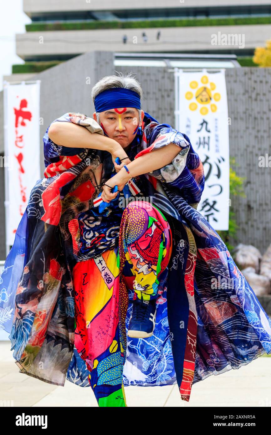 Primo piano di ballerini maschi danzanti con naruko, clappers, all'aperto al festival Kyusyu Gassai, Kumamoto. Costume tradizionale molto colorato. Rivolto Verso L'Alto. Foto Stock