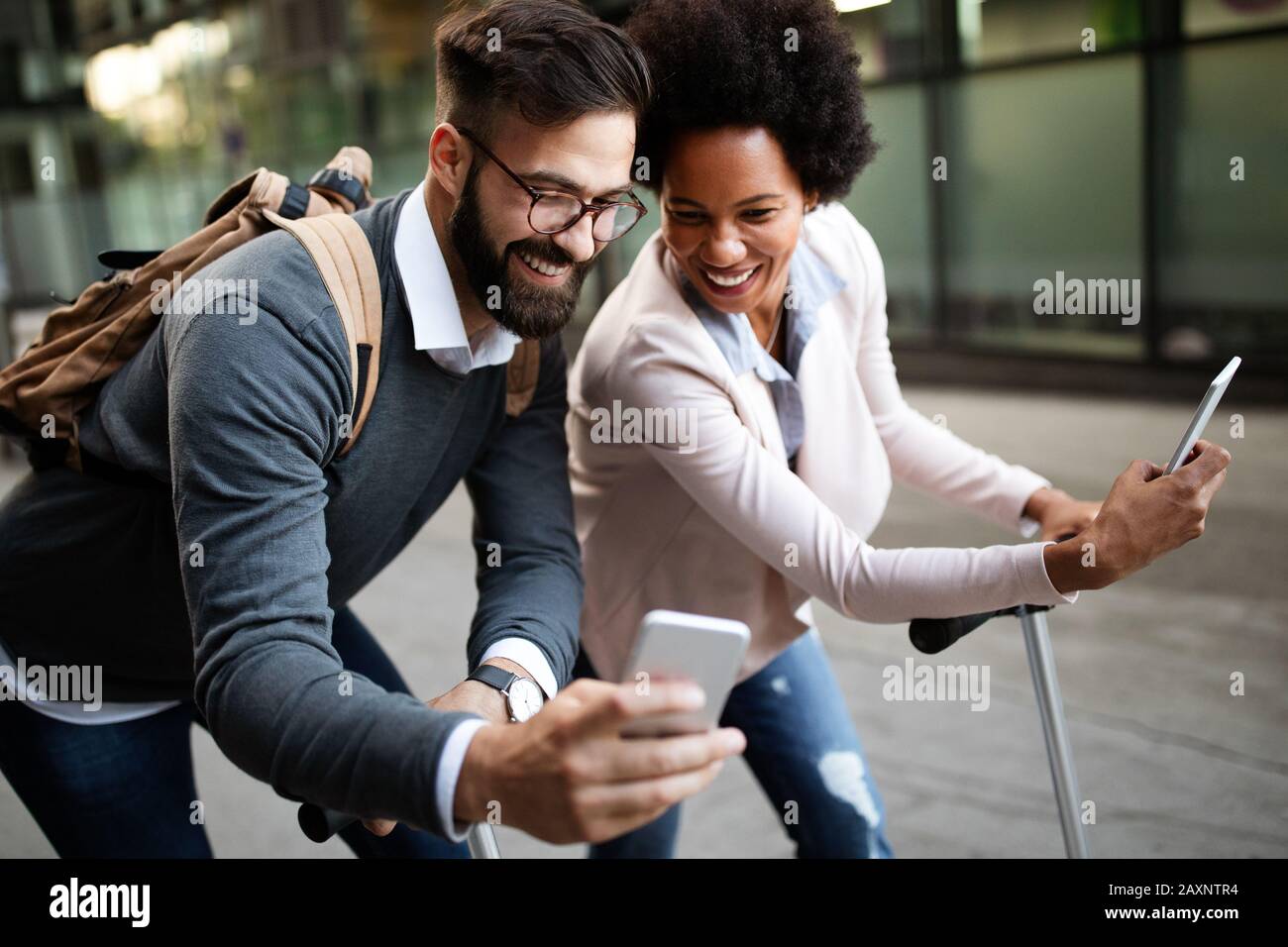 La gente di affari felice che va lavorare con lo scooter elettrico sulla strada urbana Foto Stock
