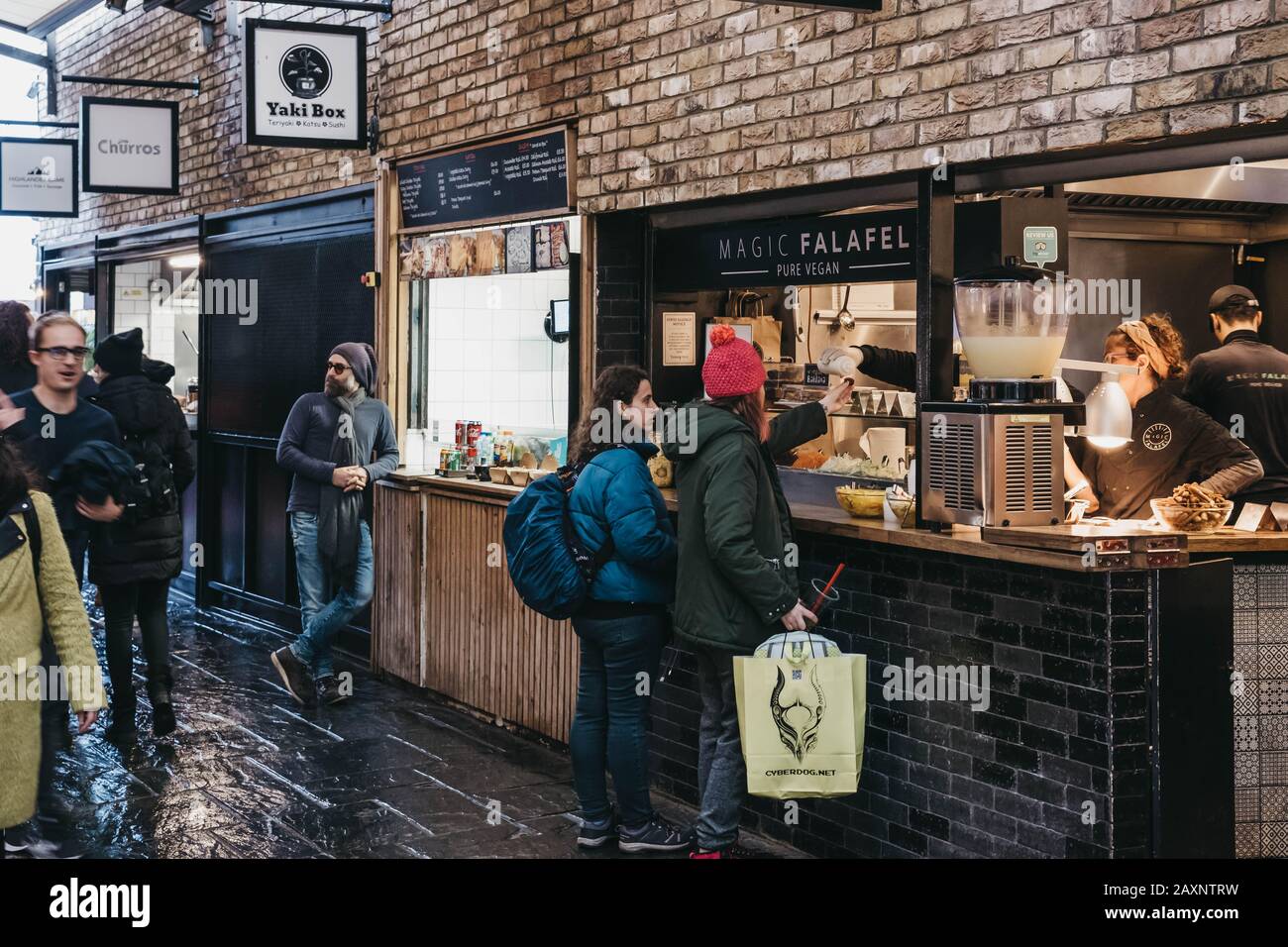 Londra, Regno Unito - 26 novembre 2019: Donne che ordinano cibo da Magic Falafel vegan food stalla a Camden Market, Londra, una delle destinazioni più trafficate per la vendita al dettaglio Foto Stock