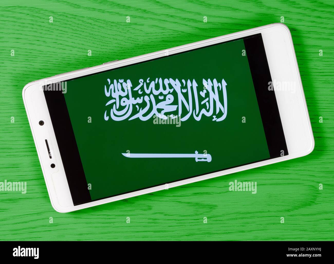 Bandiera dell'Arabia Saudita composta posizionando uno smartphone con il suo simbolo su uno sfondo di legno colorato Foto Stock