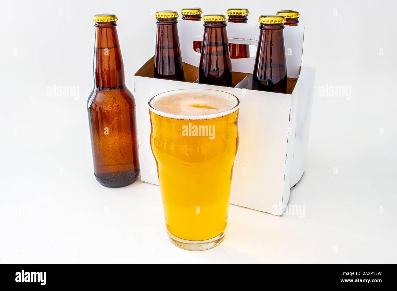 Un pacchetto di sic in bottiglia marrone Lager in Stile Pilsner con una pinta completa di birra Foto Stock