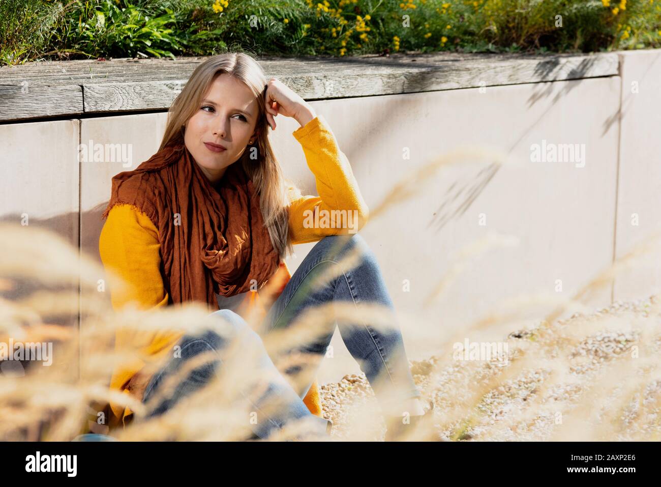 Giovane donna siede sul pavimento nel parco Foto Stock