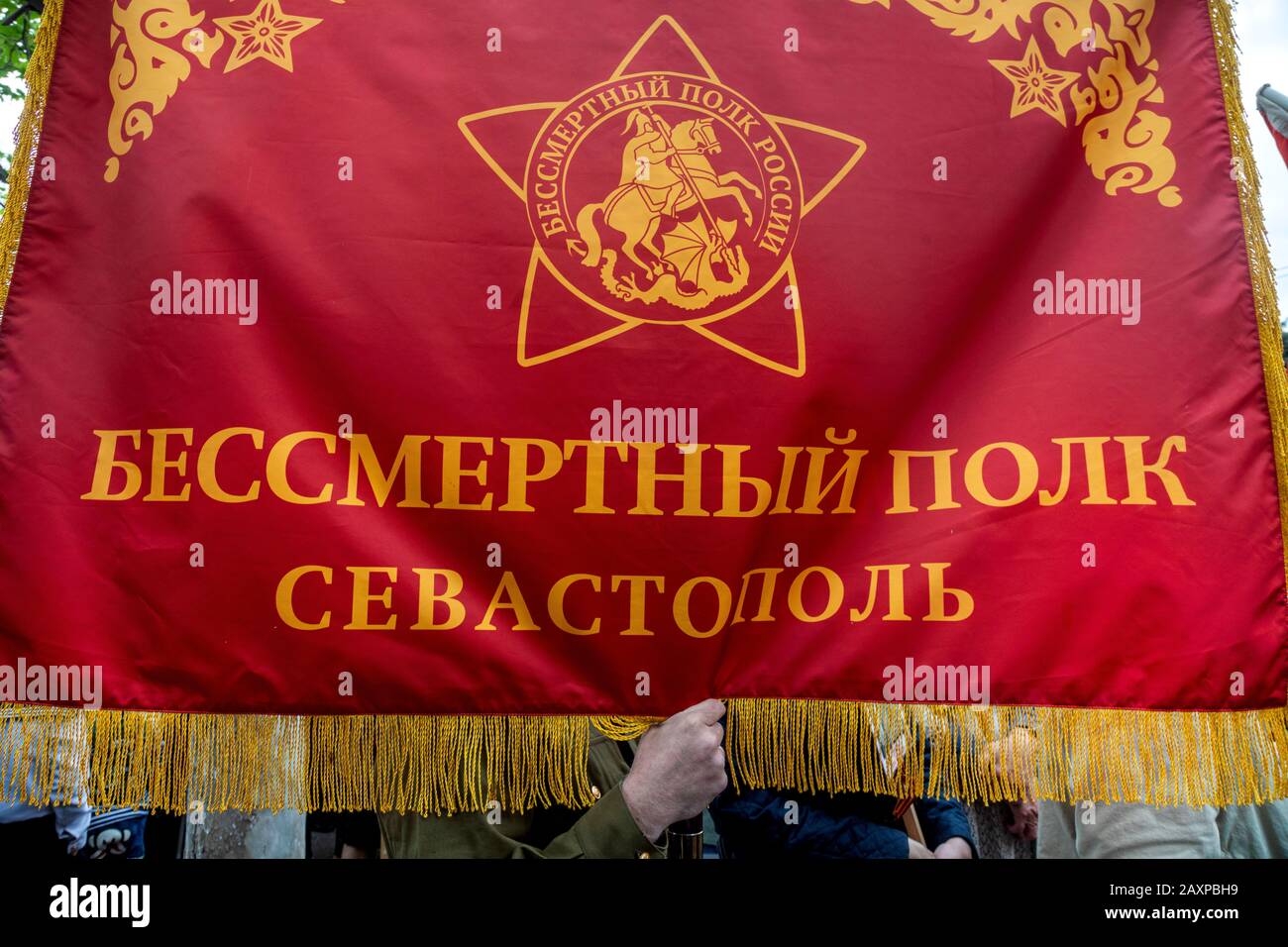 Sevastopol, 9th di maggio 2019 un uomo tiene la bandiera con l'iscrizione in russo 'Il reggimento immortale Sevastopol' durante la parata sulla strada centrale della città di Sevastopol, Crimea Foto Stock