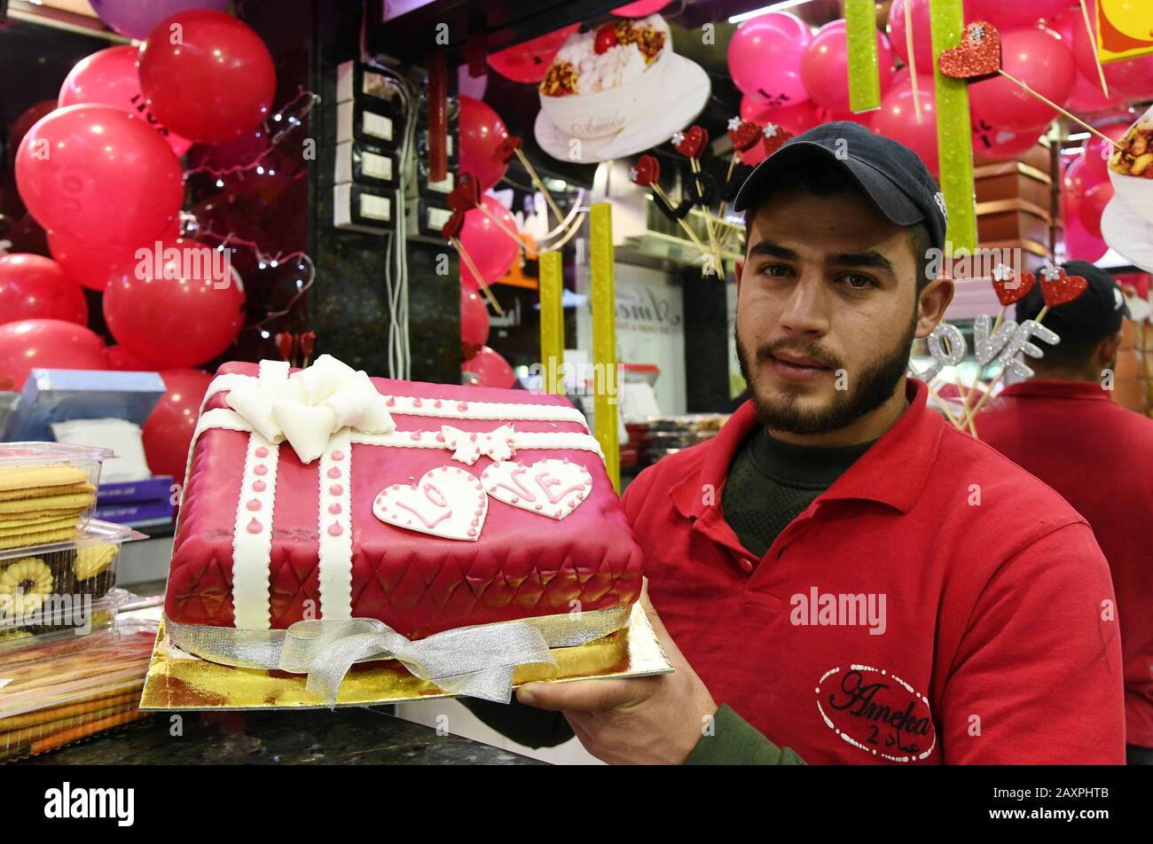 Damasco, Siria. 12th Feb, 2020. Un dolce produttore mostra una torta in occasione del giorno di San Valentino a Damasco, Siria, il 12 febbraio 2020. Credit: Ammar Safarjalani/Xinhua/Alamy Live News Foto Stock