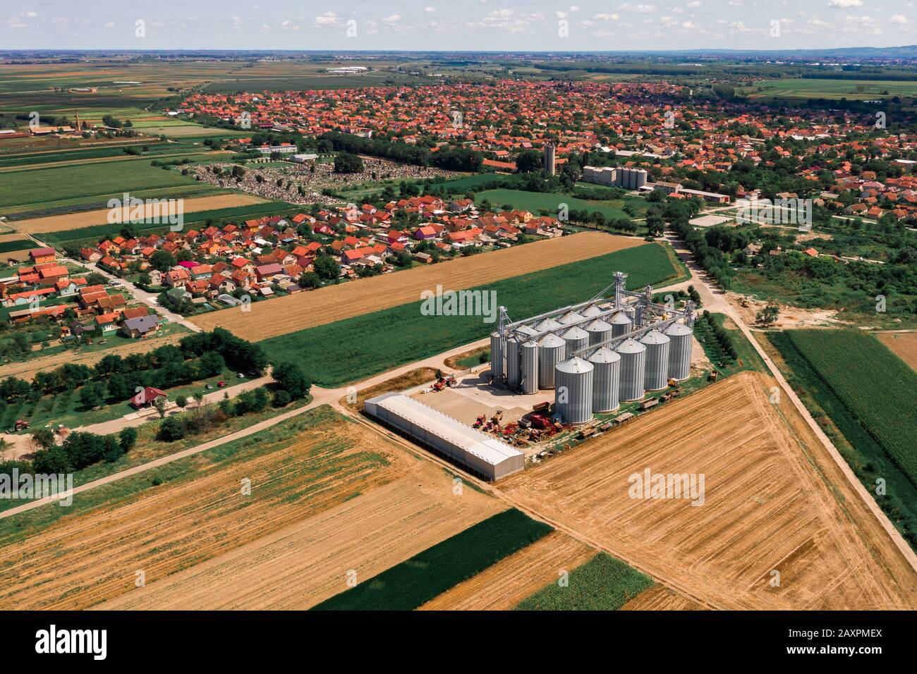 Vista aerea del silo agricoli da fuco pov. Fattoria moderna costruzione impianto al bordo del villaggio, circondato da coltivare i campi di coltivazione Foto Stock