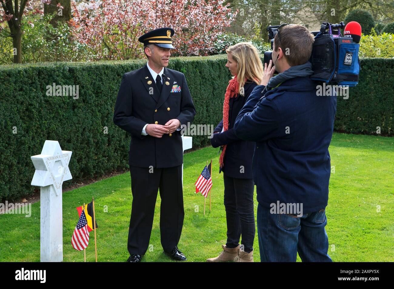 Julie Colpaert del canale televisivo belga VTM intervistando il custode della prima guerra mondiale Flanders Field American Cemetery a Waregem, Belgio Foto Stock