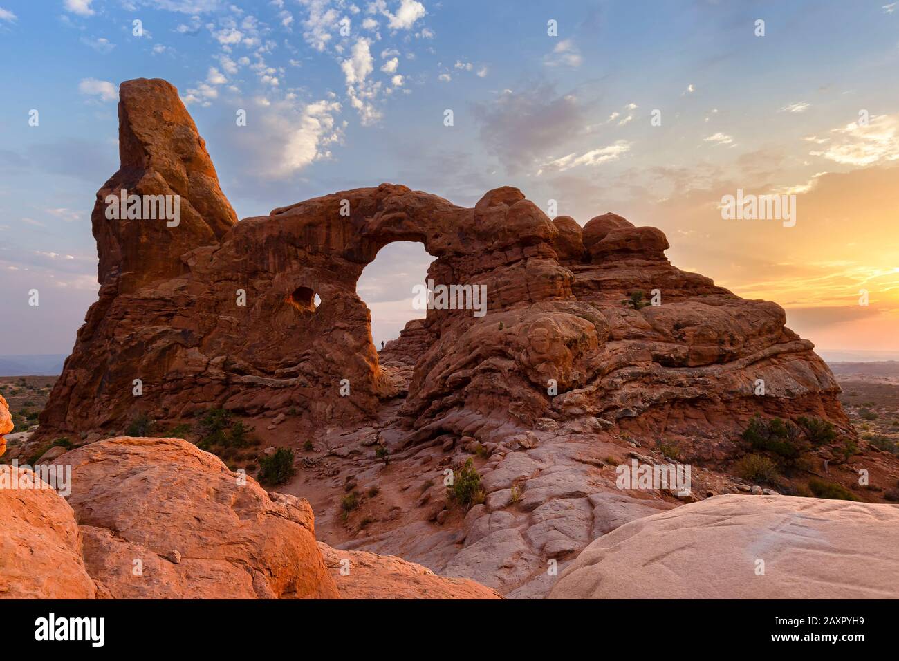 Silhouette di un escursionista incorniciato in Turret Arch Arch al tramonto nel Parco Arches Foto Stock