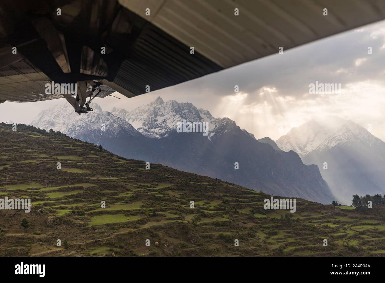 Scena di montagna e terrazze vista oltre l'ala di un piccolo aereo, Nepal Foto Stock