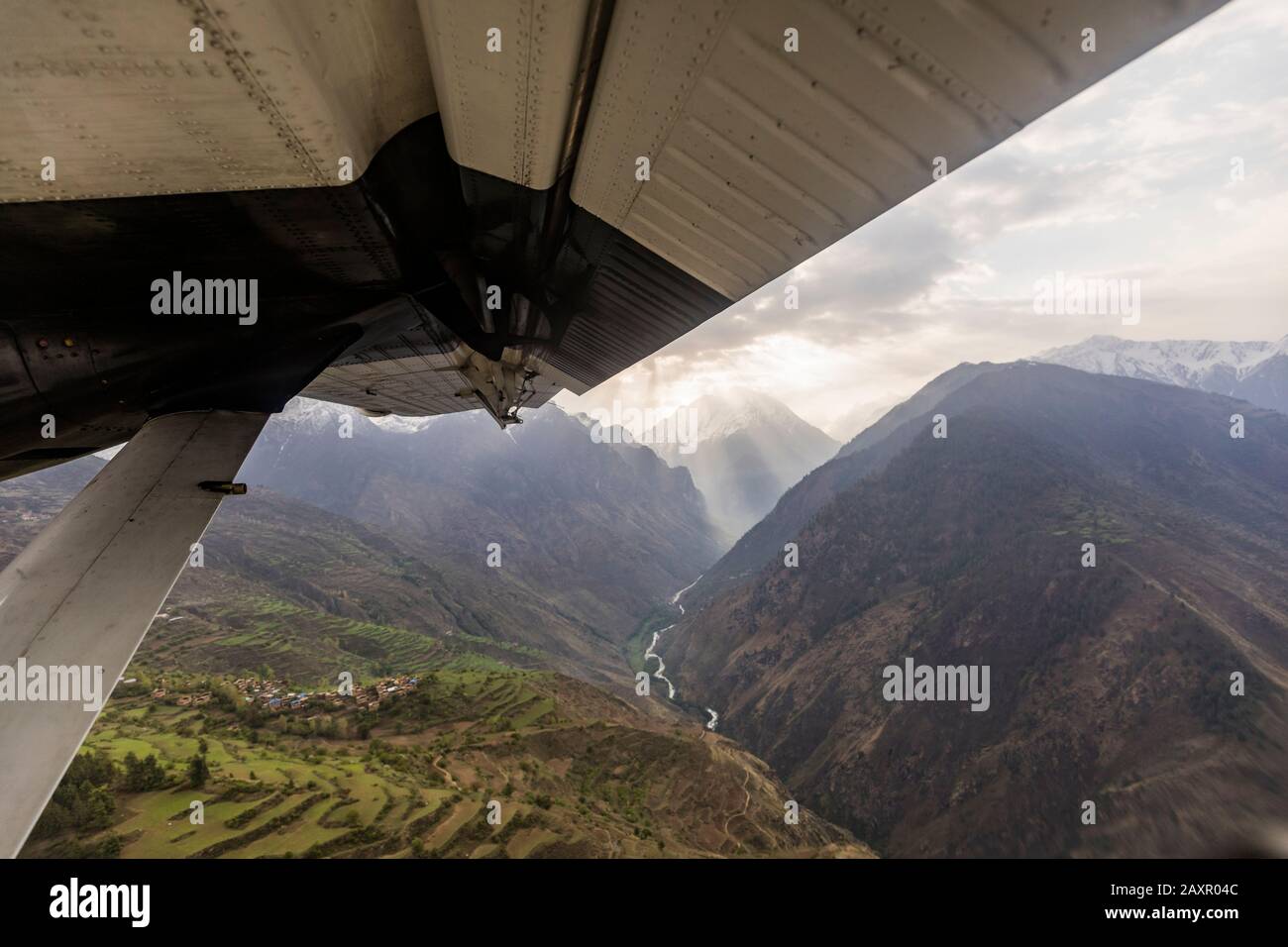 Villaggio di montagna e valle visto oltre piccolo aereo ala, Nepal Himalaya Foto Stock