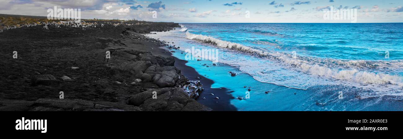 Onde che si infrangono su una spiaggia di roccia vulcanica. Foto Stock