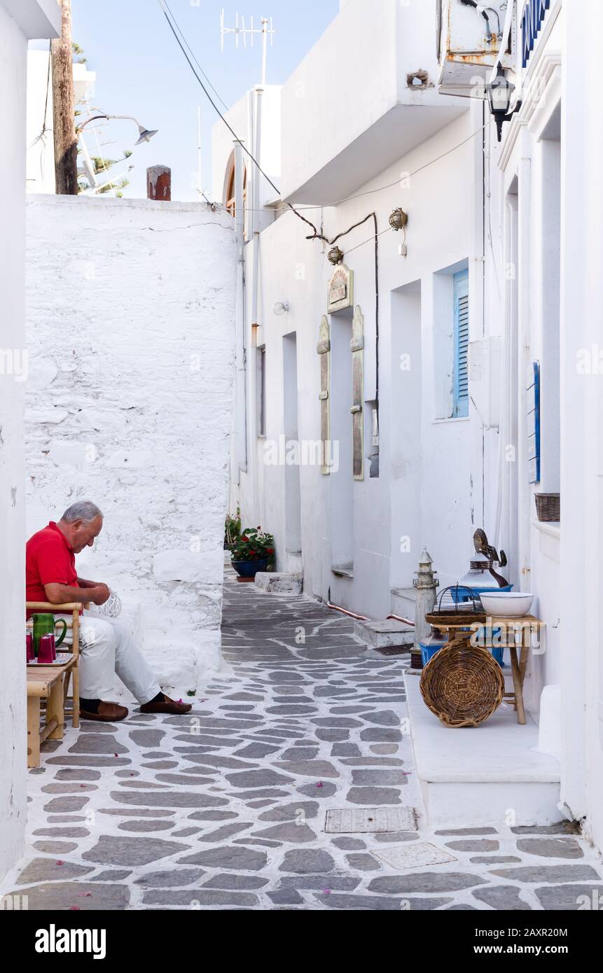 Un artigiano in una strada tipica con case bianche a Paros o Parikia, isole Cicladi, Grecia Foto Stock