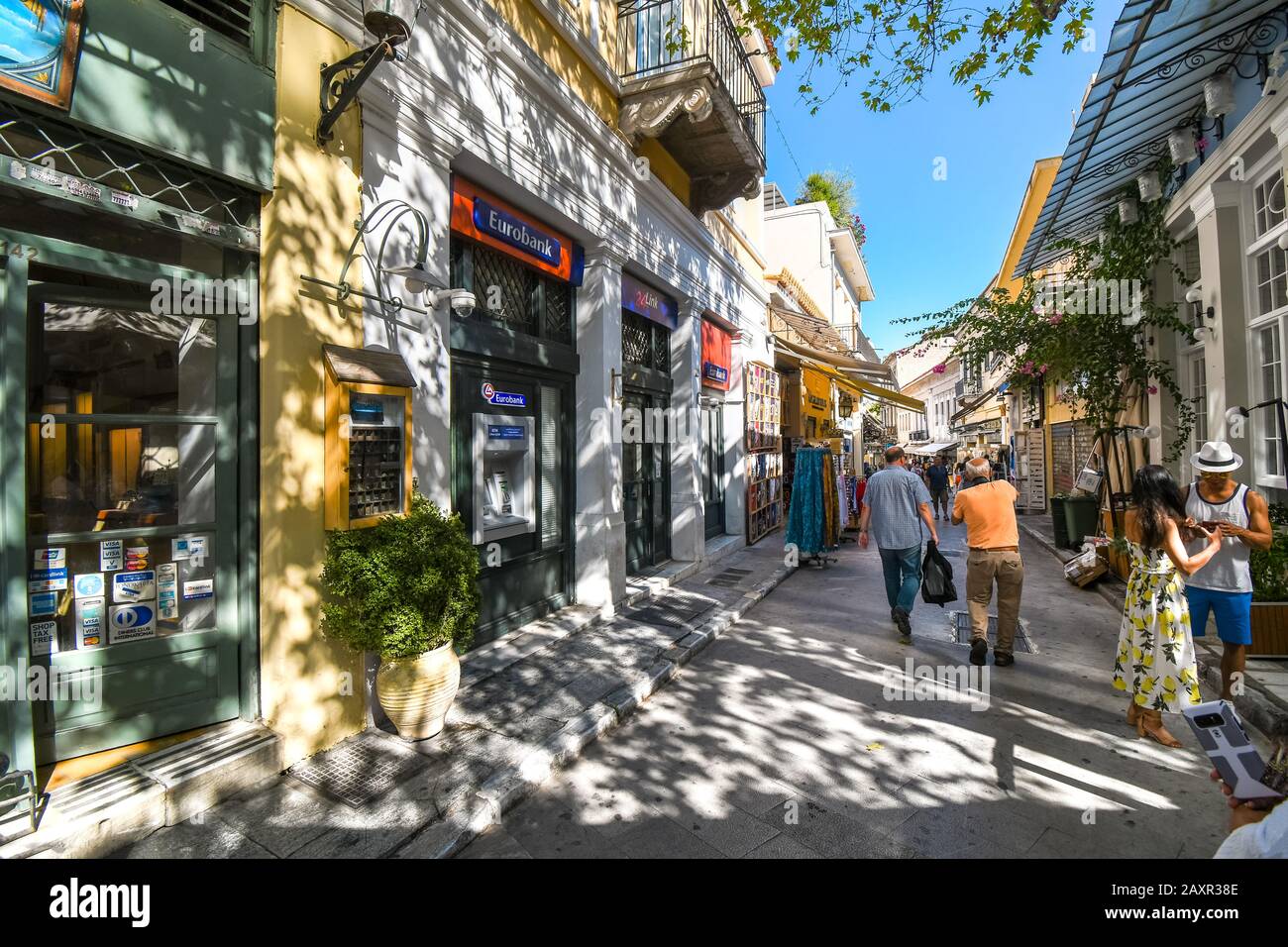 I turisti fanno shopping in una delle molte strette strade pedonali di negozi e caffetterie nello storico quartiere Plaka di Atene, Grecia. Foto Stock