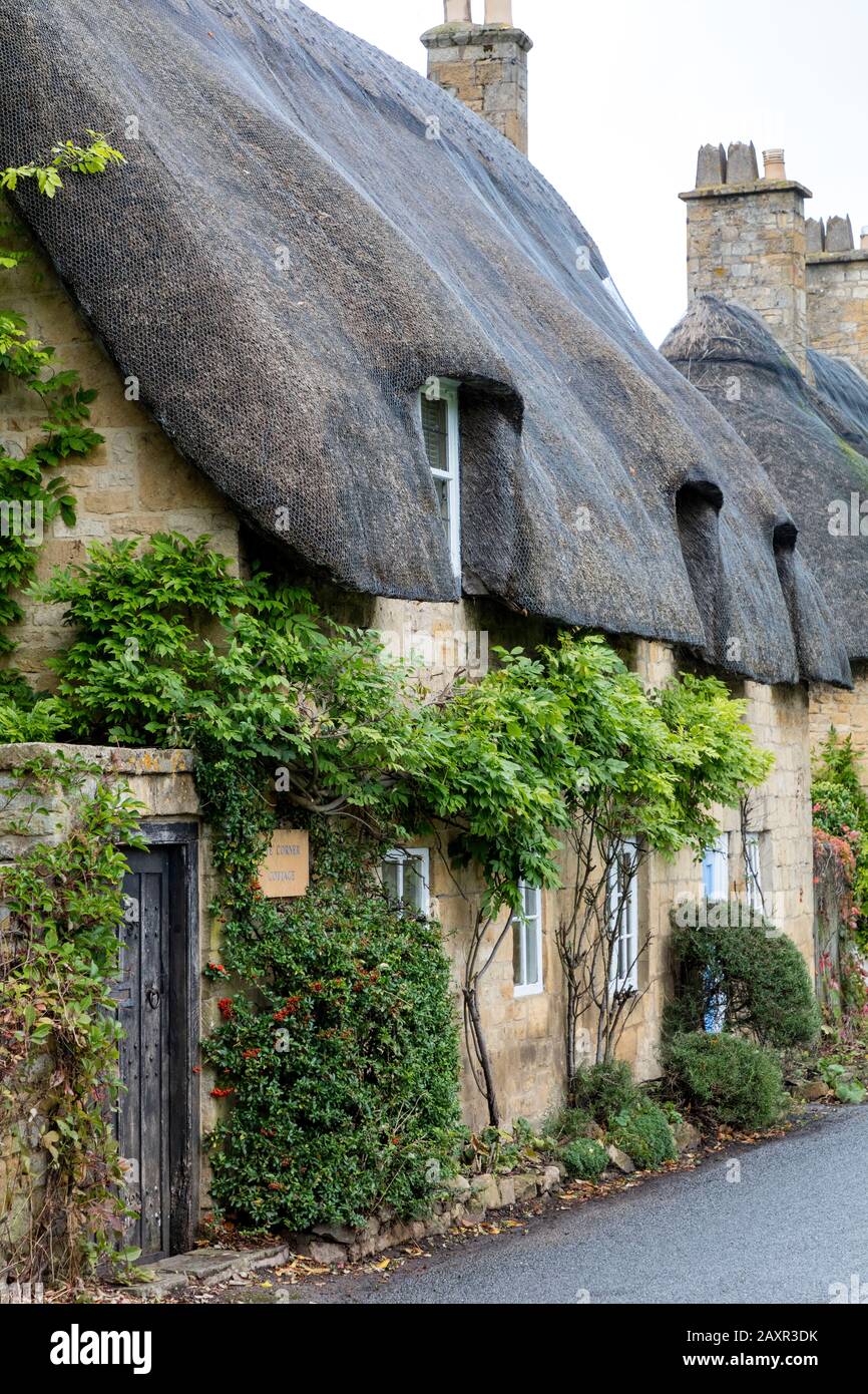 Thatch Roof Cottages lungo la strada vicino Broadway, Worcestershire, Inghilterra, Regno Unito Foto Stock