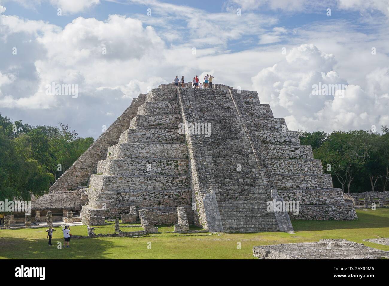 Mayapan, Messico: I turisti visitano il Tempio Maya di Kukulcan a Mayapan, la capitale dei Maya nella Yucatán dalla 1220s fino alla 1440s. Foto Stock
