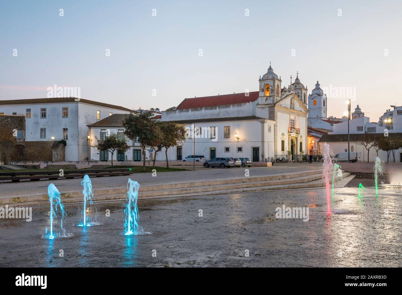 Piazza della Repubblica con fontane colorate illuminate e Chiesa di Santa Maria Igreja de Santa Maria, Lagos, Algarve, quartiere di Faro, Portogallo Foto Stock