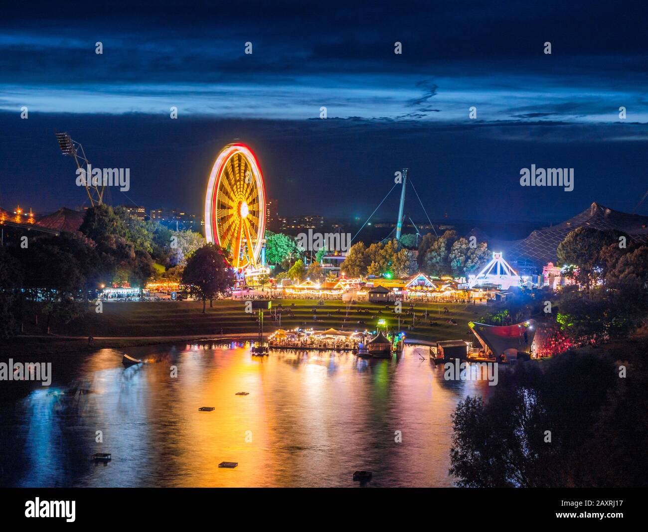 Festa estiva nel Parco Olimpico con lago olimpico di notte Monaco, Baviera, Germania, Europa Foto Stock