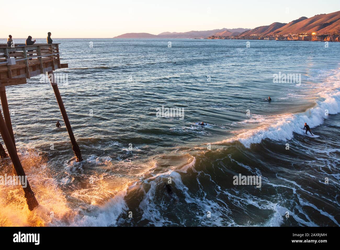 Pismo Beach California surfisti prendere un'onda al tramonto Foto Stock